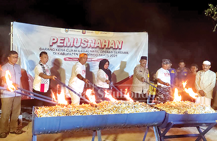 DIMUSNAHKAN: Pemkab Situbondo bersama Kepala Bea Cukai Jember membakar 139 ribu batang rokok ilegal di Pantai Pasir Putih Situbondo, Sabtu malam (4/10).