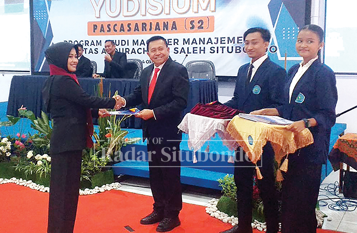SAKRAL : Direktur Pascasarjana Magister Manajemen Unars Situbondo, Dr. Mohammad Yahya Arief, SE, M.Si menyematkan tanda kelulusan kepada para mahasiswa pada acara yudisium, Sabtu kemarin (4/10.