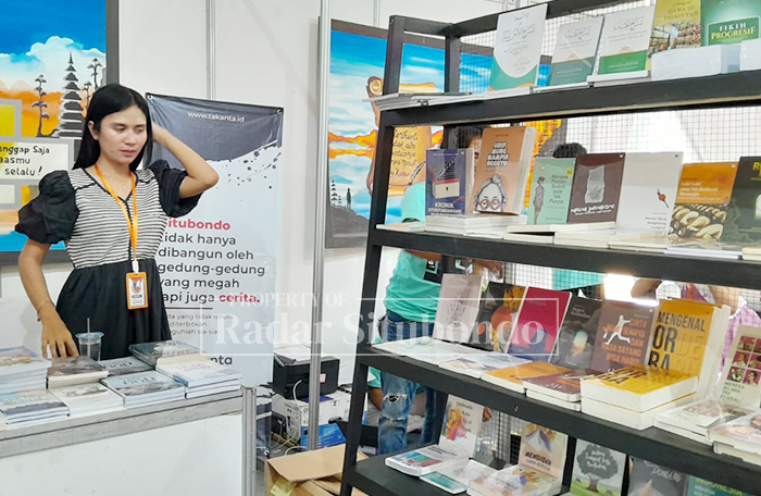 MERIAH: Salah satu pengunjung Festival Literasi Situbondo (FLS) memilih buku bacaan di bazar buku lokal Situbondo, di Alun-alun Kota, Senin (13/10).