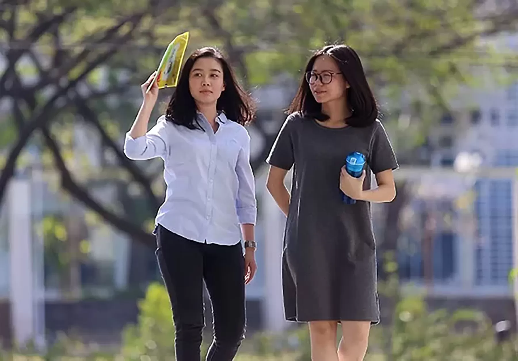 Pejalan kaki menutupi wajahnya agar terhindar dari panas.