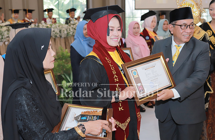 Ketua Umum Pengurus Yayasan Pendidikan Abdurachman Saleh Situbondo, Drs. H. Saifullah, MM, menyerahkan piagam penghargaan kepada Lindrawati (lulusan terbaik pascasarjana dengan IPK 4.00).