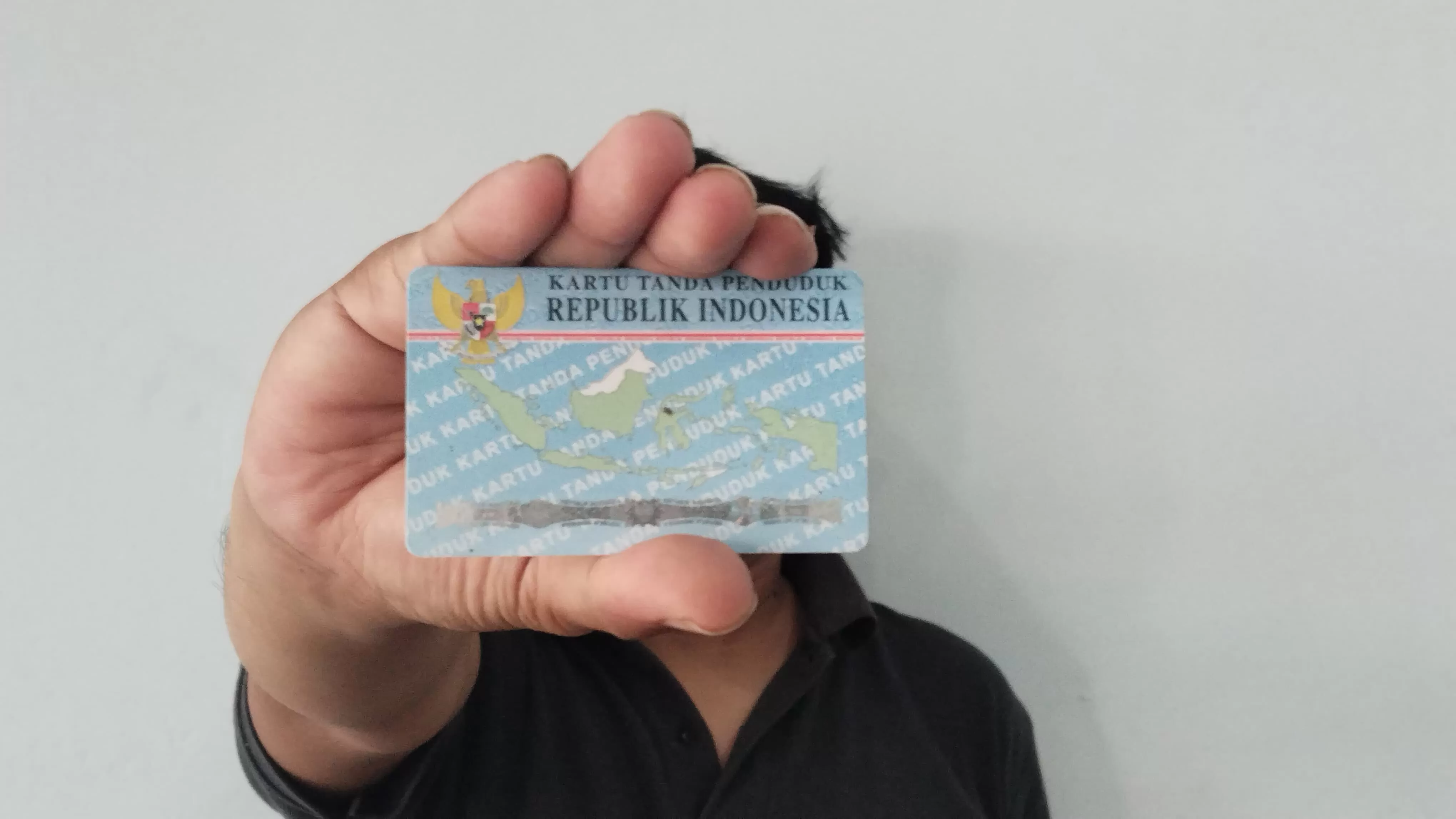 Ilustrasi seorang masyarakat menunjukkan KTP untuk disalahgunakan.