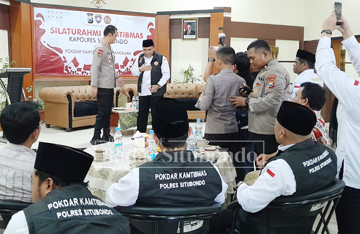 SIMBIOLIS: Kapolres Situbondo AKBP Rezi Dharmawan memasangkan rompi kepada ketua Pokdar Kamtibmas Bhayangkara Polres Situbondo, dalam acara silaturrahim di aula Sidomuncul 2, Kamis (13/11).