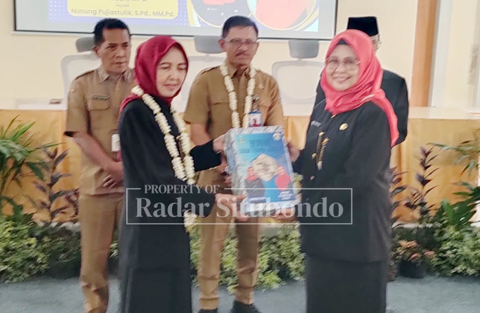 SERAH TERIMA JABATAN: Kepala SMAN 1 Panarukan, Hamida, menyerahkan dokumen kepada kepala sekolah baru, Nunung Pujiastutik, Selasa (9/12).