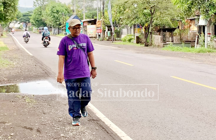 TUNAIKAN NIAT: Seorang warga Dusun Sletreng, Desa Kalianget, Kecamatan Banyuglugur, berjalan kaki menuju Pendapa Rakyat Situbondo untuk menunaikan nadzarnya, Sabtu (10/1).