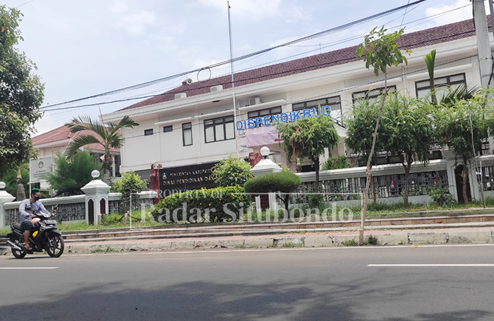 JAM KERJA: Pengemudi motor melintas di depan gedung Dinas Pendidikan Situbondo, Senin (19/1)