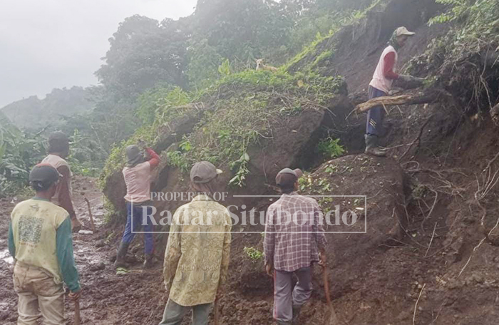 BENCANA ALAM: Sejumlah warga kerja bakti menyingkirkan batu besar di Badan Jalan Padukuhan Kerpang dan Pocok, Dusun Cobbuk, Desa Curahtatal, Kecamatan Arjasa, Senin (19/1).