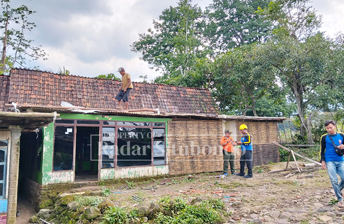 DITERJANG ANGIN: Anggota BPBD Situbondo meninjau rumah rusak akibat angin kencang di Desa Kembang Sari, Kecamatan Jatibanteng, Minggu (25/1).