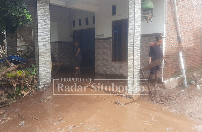 BENCANA ALAM: Warga terdampak banjir membersihkan sisa-sisa lumpur akibat terjangan banjir bandang di Kecamatan Besuki, Sabtu (24/1).