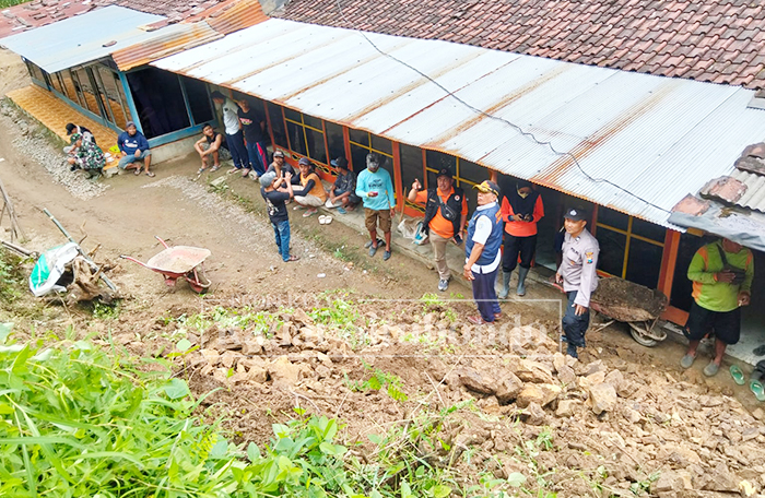 TETAP SIAGA: Petugas dari kepolisian dan Badan Penanggulangan Bencana Daerah (BPBD) Situbondo meninjau lokasi tanah longsor di Dusun Alaspinang, Desa Sumberpinang, Mlandingan.