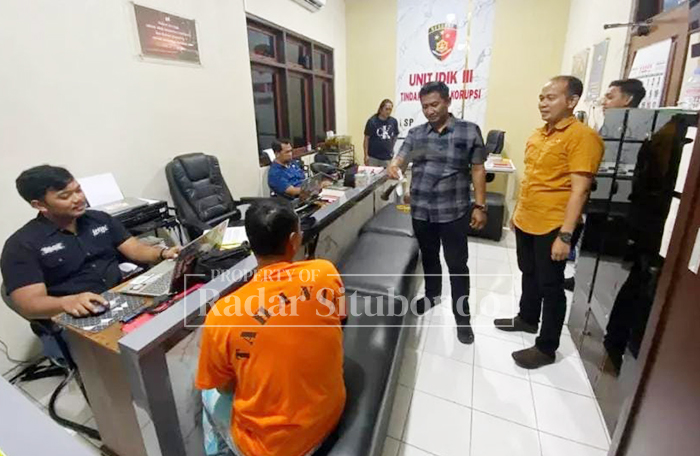 PAKAI BAJU TAHANAN: Tersangka Sanusi Amrin menjalani pemeriksaan di ruang penyidikan Polres Situbondo, Selasa malam (27/1).