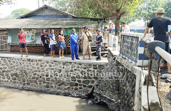 MENGHEBOHKAN: Anggota Polres Situbondo meninjau mayat yang mengapung di sungai di Dusun Gelung Barat, Desa Gelung, Kecamatan Panarukan, Minggu (1/2).
