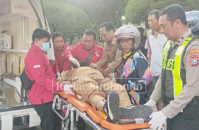 EVAKUASI MAYAT: Anggota Polres Situbondo dibantu tim medis mengevakuasi mayat di pinggir Alun-alun Kota Situbondo, Senin (2/1).