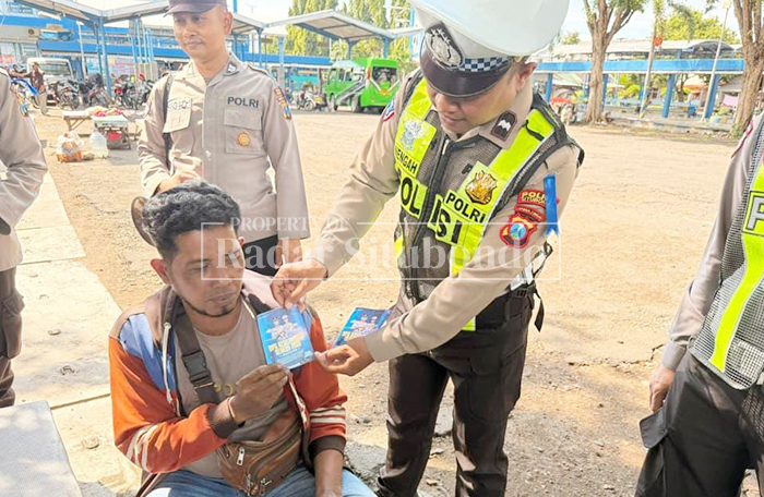 MENYAPA WARGA: Anggota Satlantas Polres Situbondo membagikan brosur tertib berlalulintas dalam Operasi Keselamatan Semeru 2026, Jumat (6/2).