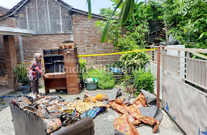 DIBAKAR: Sunarya, 50, warga Dusun Langai, Desa Sumberkolak, Kecamatan Panarukan, menunjukkan perabotan rumah hangus terbakar, Jumat (6/2).