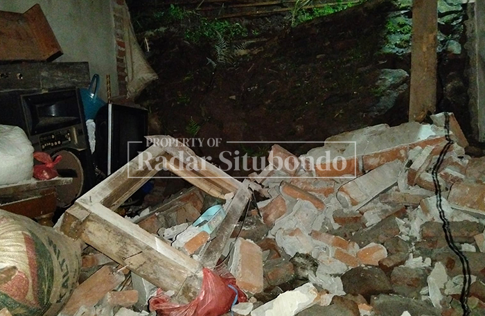 TERTIMPA TANAH: Tembok Penahan Tanah (TPT) longsor menimpa rumah warga di Desa Baderan, Kecamatan Sumbermalang, Kabupaten Situbondo, Kamis (5/2) malam.