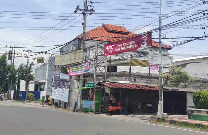 BELUM DICOPOT: Penampakan iklan atau spanduk di kawasan perempatan Jalan Argopuro Krajan, Mimbaan, Kecamatan Panji, Situbondo, Jumat (6/2).