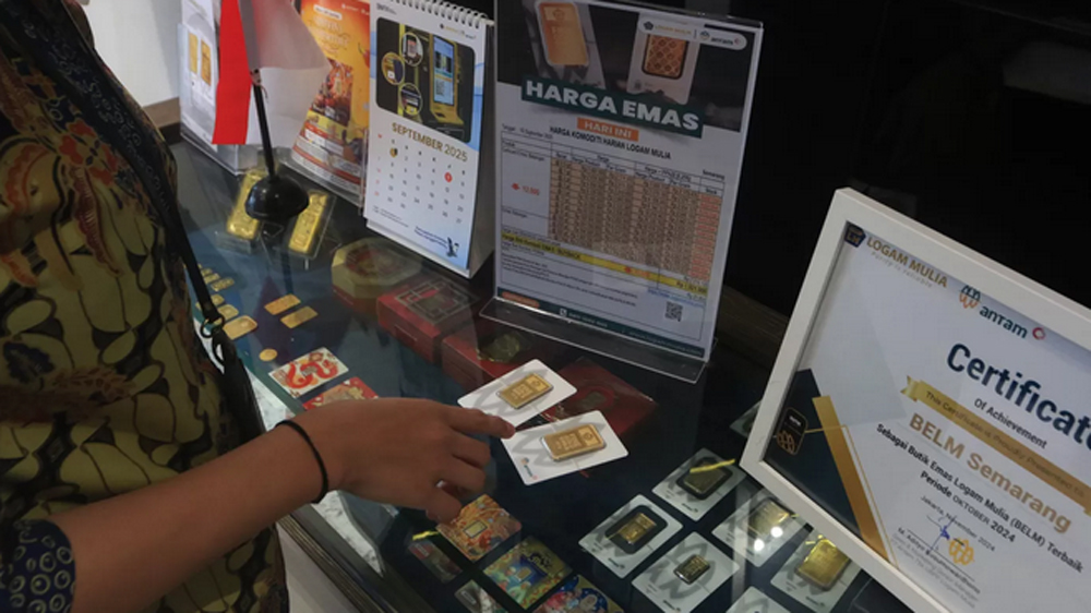 ILUSTRASI: Petugas Butik Emas Logan Mulia Antam menunjukkan replika logam mulia keluaran PT ANTAM di butik emas di rukan DP Mall, Jalan Pemuda, Kota Semarang, beberapa waktu lalu.