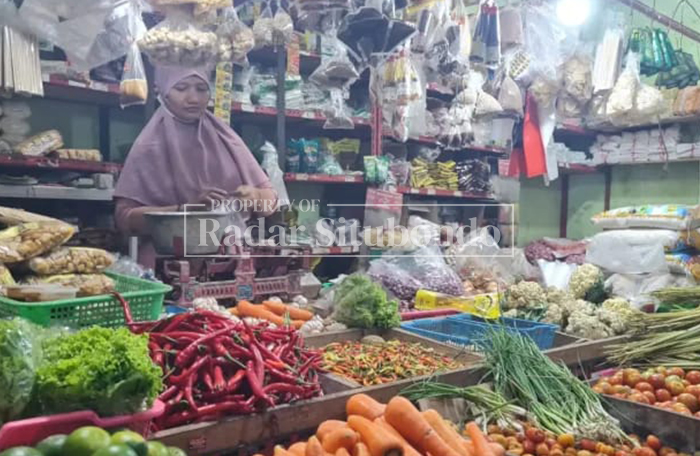 MENUNGGU PEMBELI: Seorang pedagang sembako di pasar tradisional Situbondo mengeluhkan harga bahan pokok yang terus naik, Minggu (15/2).