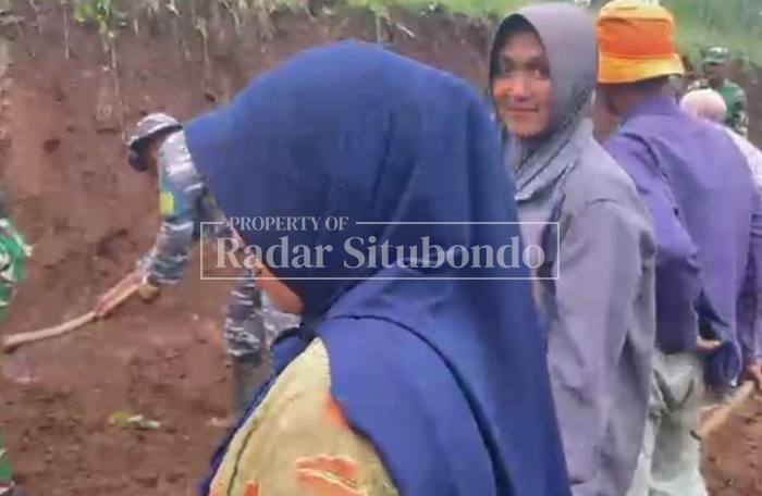 IKUT MENCANGKUL: Ibu-ibu warga Dusun Pelampang, Desa Alas Tengah, Kecamatan Sumbermalang, Situbondo membantu membuka akses jalan terpencil bersama TNI, Selasa (16/2).