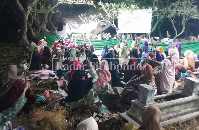DOA BERSAMA: Warga Dusun Cangkring, Desa Curahtatal, Kecamatan Arjasa nyekar ke kuburan, Senin malam (16/2).