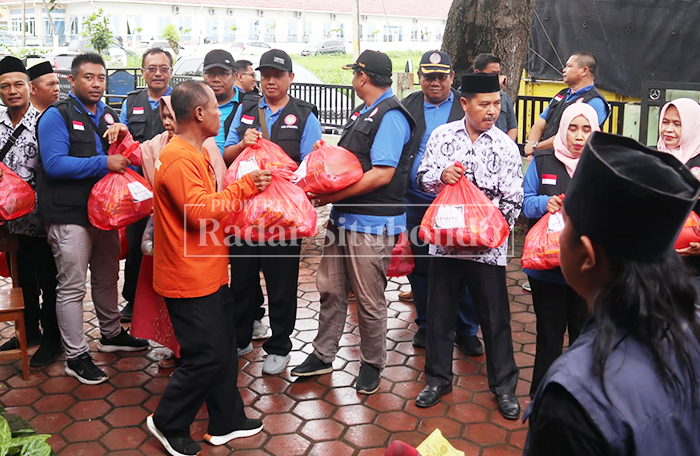 BANTUAN: Ketua PGRI bersama Kepala Dispendikbud Situbondo, Sopan Efendi, memberikan paket sembako kepada korban terdampak banjir di Kecamatan Banyuglugur, Situbondo, Senin (16/2).