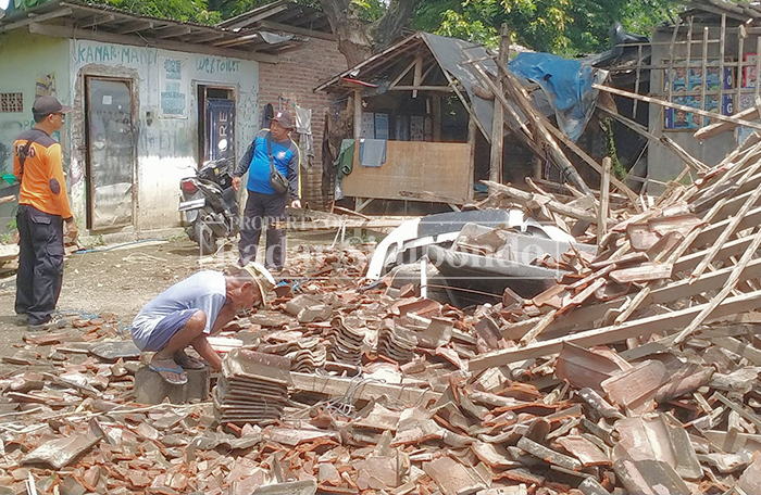 DIGUYUR HUJAN: Anggota BPBD Situbondo meninjau rumah roboh milik Sudarsono, 57, warga Kampung Sidomulyo, Desa Sumberwaru, Kecamatan Banyuputih, Selasa (17/2).