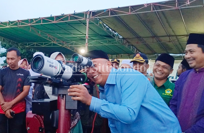 MELIHAT TANDA PUASA: Bupati Situbondo, Yusuf Rio Wahyu Prayogo, saat mencoba teleskop (teropong) untuk melihat hilal sebagai tanda masuknya bulan suci Ramadan di Pelabuhan Kalbut.