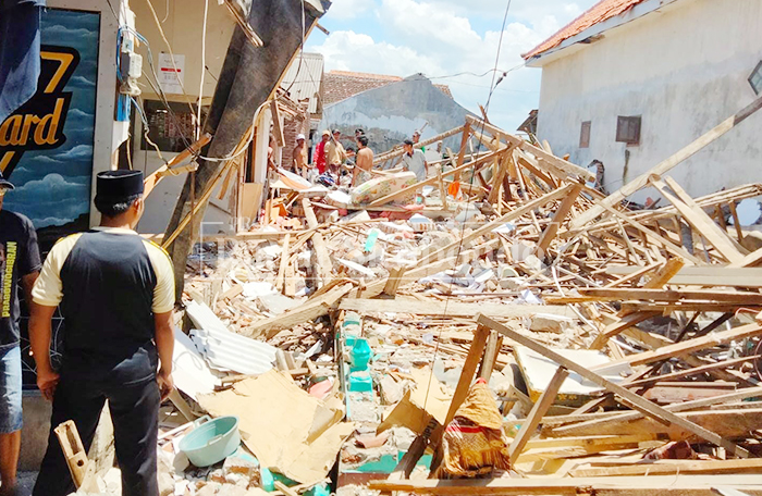 STERIL: Sejumlah warga mengevakuasi perabotan di bawah reruntuhan rumah milik Nenek Kulsum, 60, warga Dusun Mimbo, Desa Sumberanyar, Kecamatan Banyuputih, Minggu (22/2).  