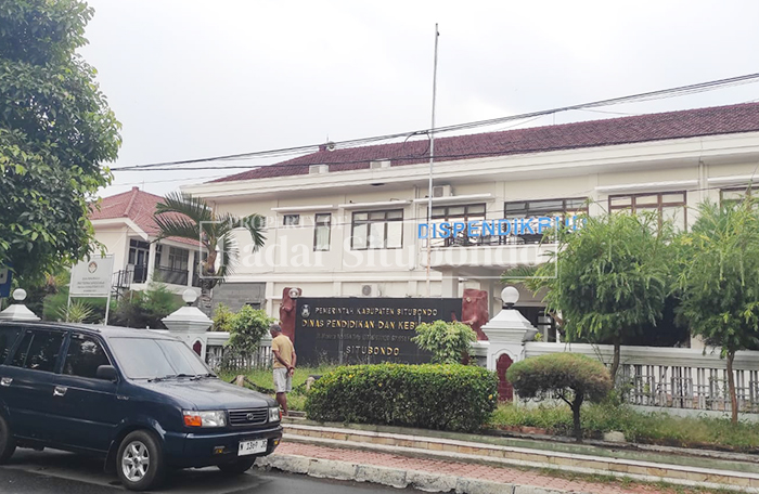 DEPAN PAGAR: Seorang warga berdiri di depan gedung kantor Dinas Pendidikan dan Kebudayaan (Dispendikbud) Kabupaten Situbondo, Jumat (27/2). 