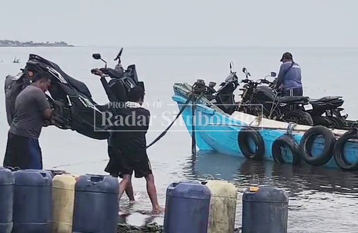 JALAN PINTAS: Nelayan menaikkan sepeda motor pemudik ke atas kapal motor di pesisir Pelabuhan Kesyahbandaran Jangkar, Senin lalu (3/3). 