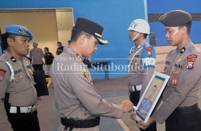 PECAT ANGGOTA: Kapolres Situbondo AKBP Bayu Anuwar Sidiqie mencoret foto oknum anggota Bripka DK, 27, di Lapangan Apel Polres Situbondo, Rabu lalu (5/3). 