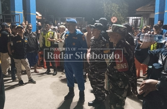 KOMPAK: Anggota Satpolairud Polres Situbondo dan anggota TNI berada di tengah kerumunan pemudik di Pelabuhan Jangkar, Minggu malam (9/3). 