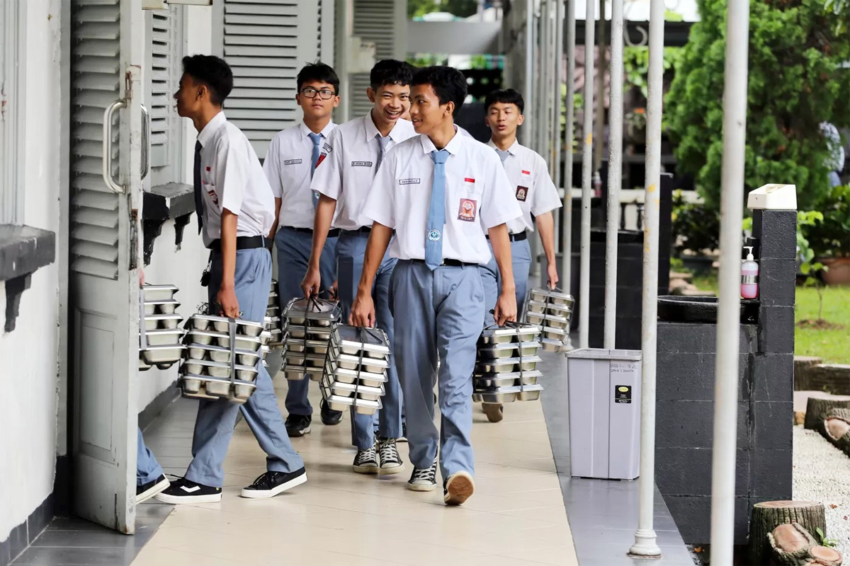 Sekelompok siswa sedang mengangkut MBG.