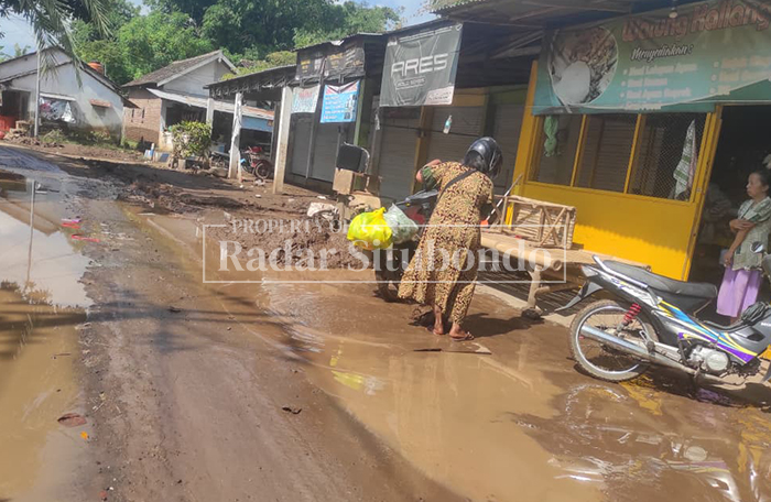 PASCA BENCANA: Warga melakukan bersih-bersih di halaman rumahnya setelah terdampak banjir untuk ketiga kalinya, Kamis (12/3). 