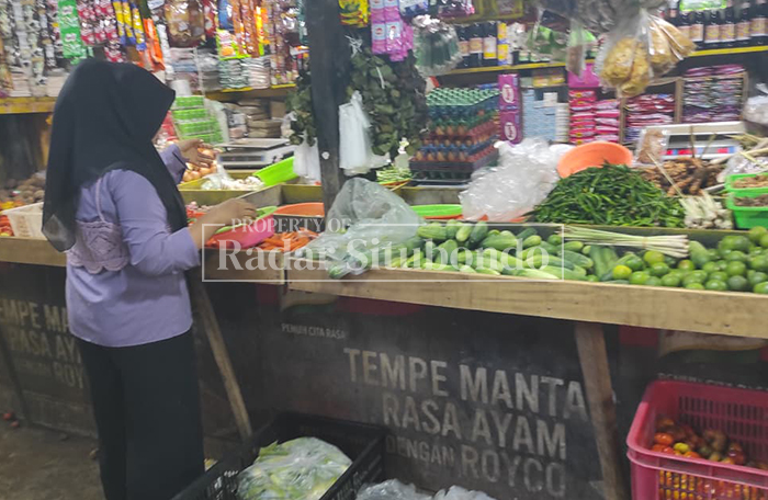 DEPAN KIOS: Seorang pembeli saat memilih bahan pokok di salah satu kios di Pasar Panji, Kecamatan Panji, Senin (16/3). 