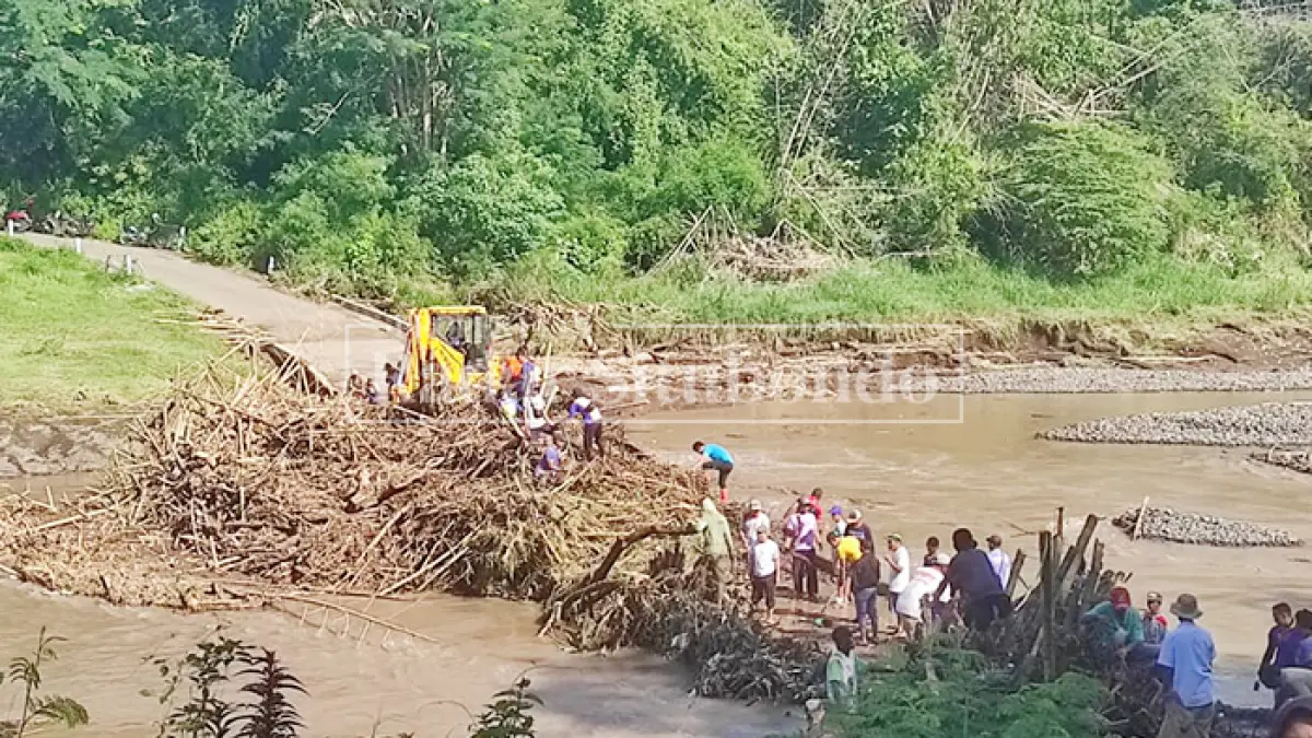 GOTONG ROYONG: Warga bersama petugas melakukan pembersihan ranting kayu dan sampah lainnya yang menyangkut di jembatan limpas Desa Siliwung, Kecamatan Panji. Kondisi tersebut sempat menjadi tontonan warga, Selasa (31/3). (Ahmad Rifa