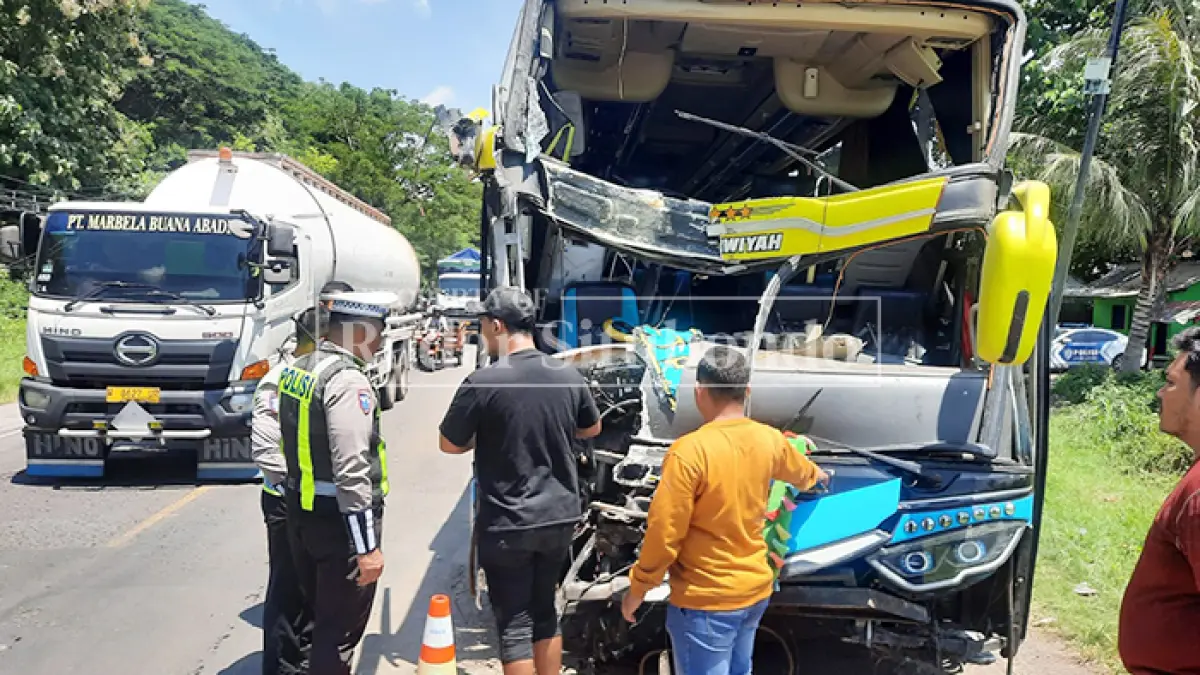 LAKA MAUT: Anggota Kanitlaka Polres Situbondo meninjau bus PT Grahita Mojokerto di pinggir Jalan Raya, Desa Klatakan, Kecamatan Kendit, Selasa (31/3). (HUMAIDI/JPRS)