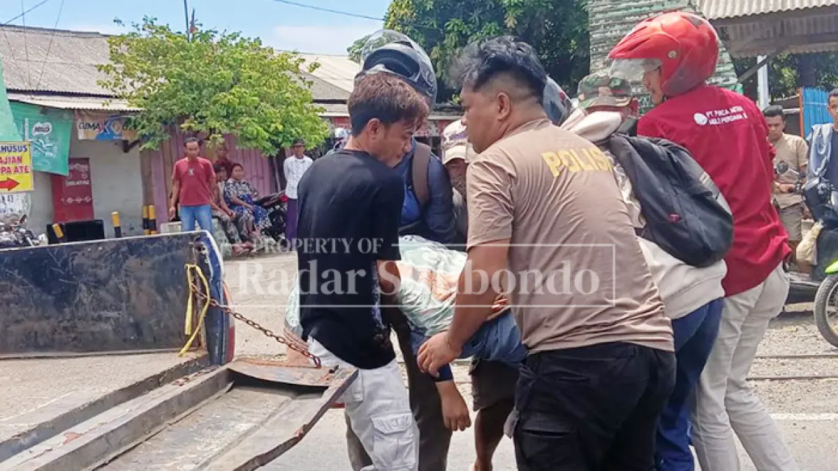 LAKA MAUT: Anggota Kanitlaka dibantu warga menggotong jenazah Ifa, warga  Desa Pokaan, Kecamatan Kapongan, di Jalan Raya, Desa Landangan, Kecamatan Kapongan, Jumat (3/4). (HUMAIDI/JPRS)
