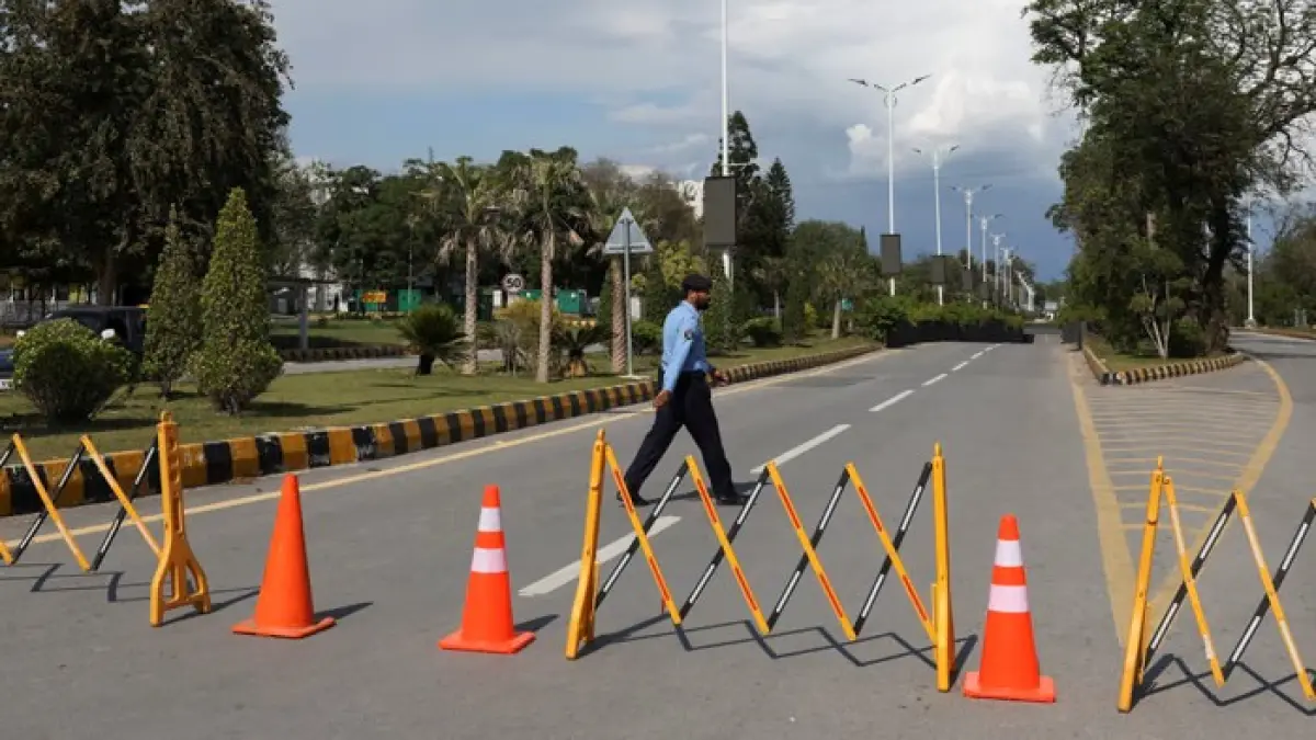 Seorang petugas polisi berjalan di jalan yang diblokir karena tindakan keamanan, menuju Hotel Serena, Islamabad, tempat para delegasi dalam pembicaraan tersebut diperkirakan akan menginap. (The Guardian)