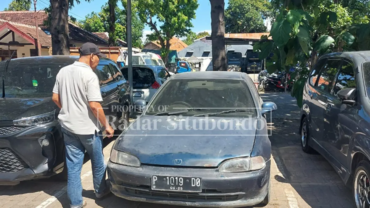 BARANG BUKTI: Salah satu jurnalis melihat nopol mobil barang bukti di halaman belakang Mapolres Situbondo, (15/4). (HUMAIDI/JPRS)
