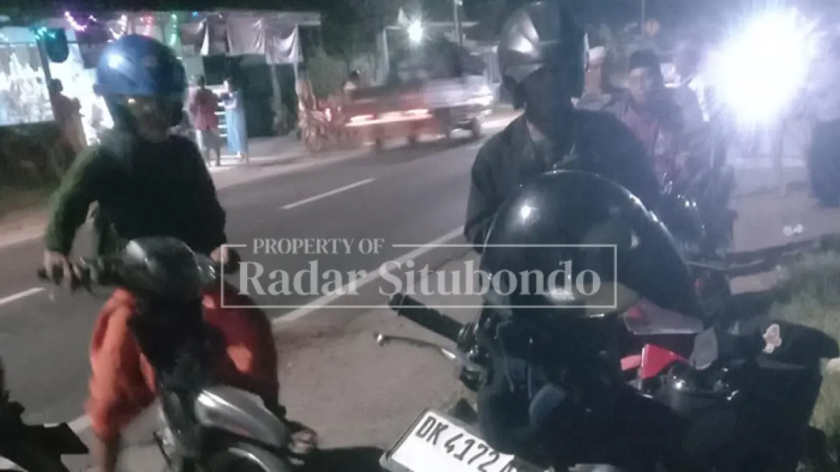 LAKA MAUT: Pengendara motor melihat motor milik korban kecelakaan di Jl. Raya Desa Kalibagor, Kecamatan/Kota Situbondo, Sabtu malam (18/4). (HUMAIDI/JPRS)
