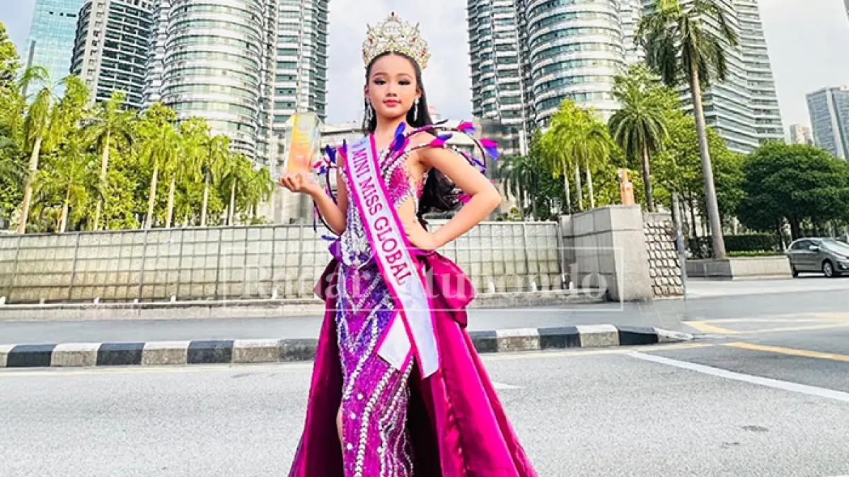 BAHAGIA: Vellencia Gunawan, menunjukkan piala juara 1 Mini Miss Global 2026, di bawah Menara Kembar Petronas, Malaysia, Kamis lalu (9/4). (Vallencia Gunawan untuk JPRS)