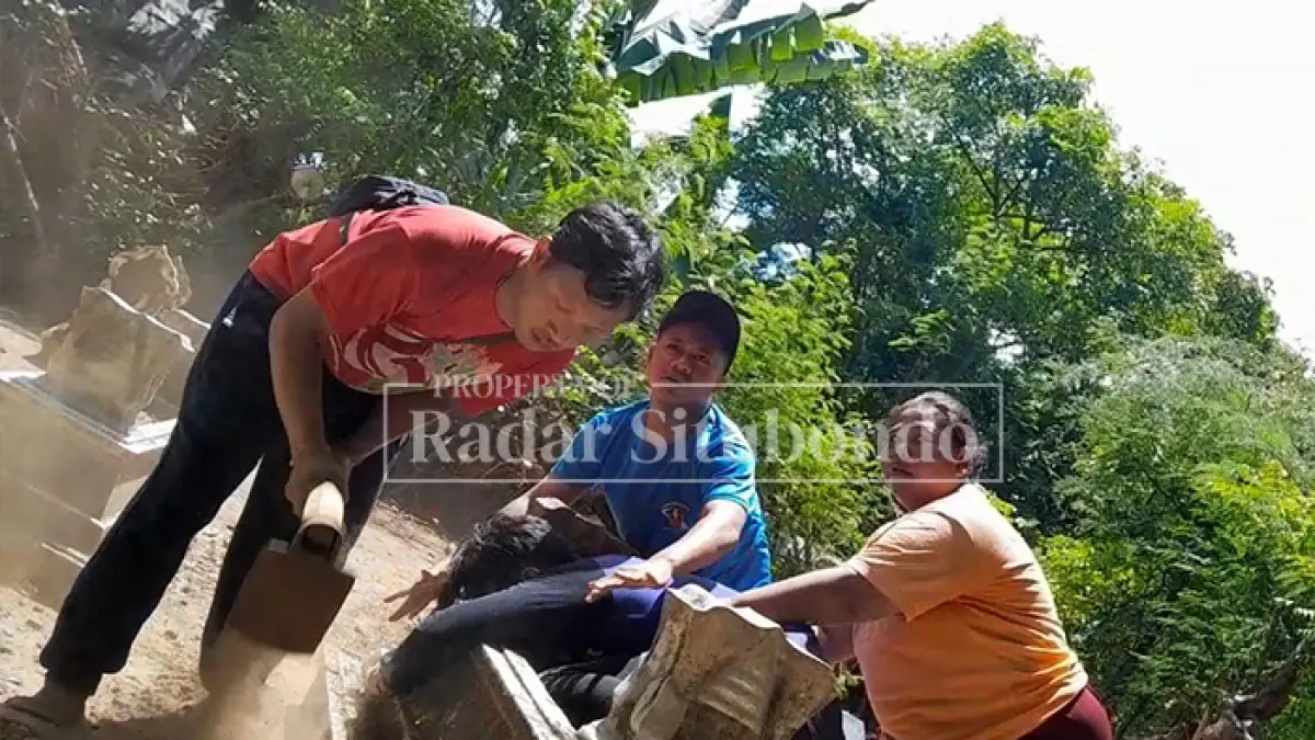 KECEWA: Hairul pemilik rumah di Desa Juglangan, Kecamatan Panji, didampingi kakak kandungnya Fathor Rosi, menggali kuburan nenek moyangnya, Rabu (22/4). (HUMAIDI/JPRS)
