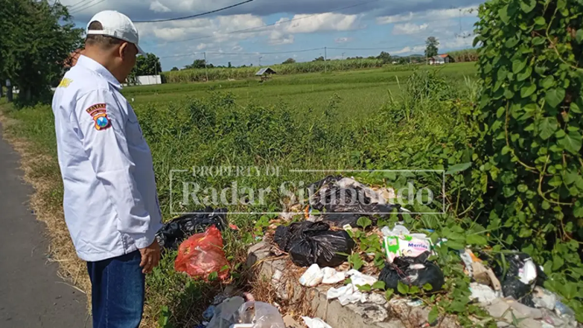 BIKIN RESAH: Kapokdar Kamtibmas Polres Situbondo H. Moh. Hijir Ismail, menijau sungai penuh sampah, di Nyamplong di Desa Gebangan, Kecamatan Kapongan, Rabu (29/4). (HUMAIDI/JPRS)
