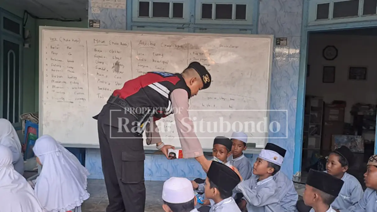 JUMAT BERKAH:Anggota Sabhara Polres Situbondo membagikan Alquran kepada puluhan santri di di LKSA Nurul Ihsan, Desa/ Kecamatan Kendit, Jumat lalu (1/5). (HUMAIDI/JPRS)
