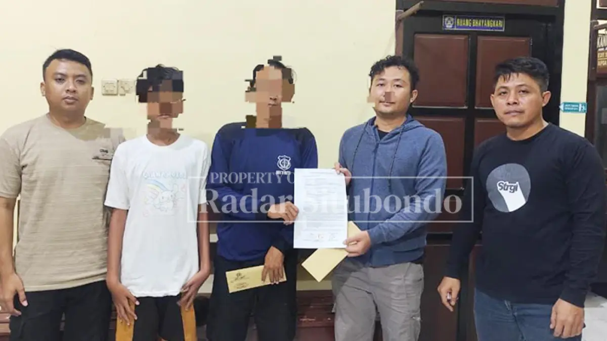KAUS PUTIH: MR, 13, didampingi sang ayah menujukkan bukti pernyataan di Kantor Polsek Panarukan, Selasa malam (5/5). (HUMAIDI/JPRS)
