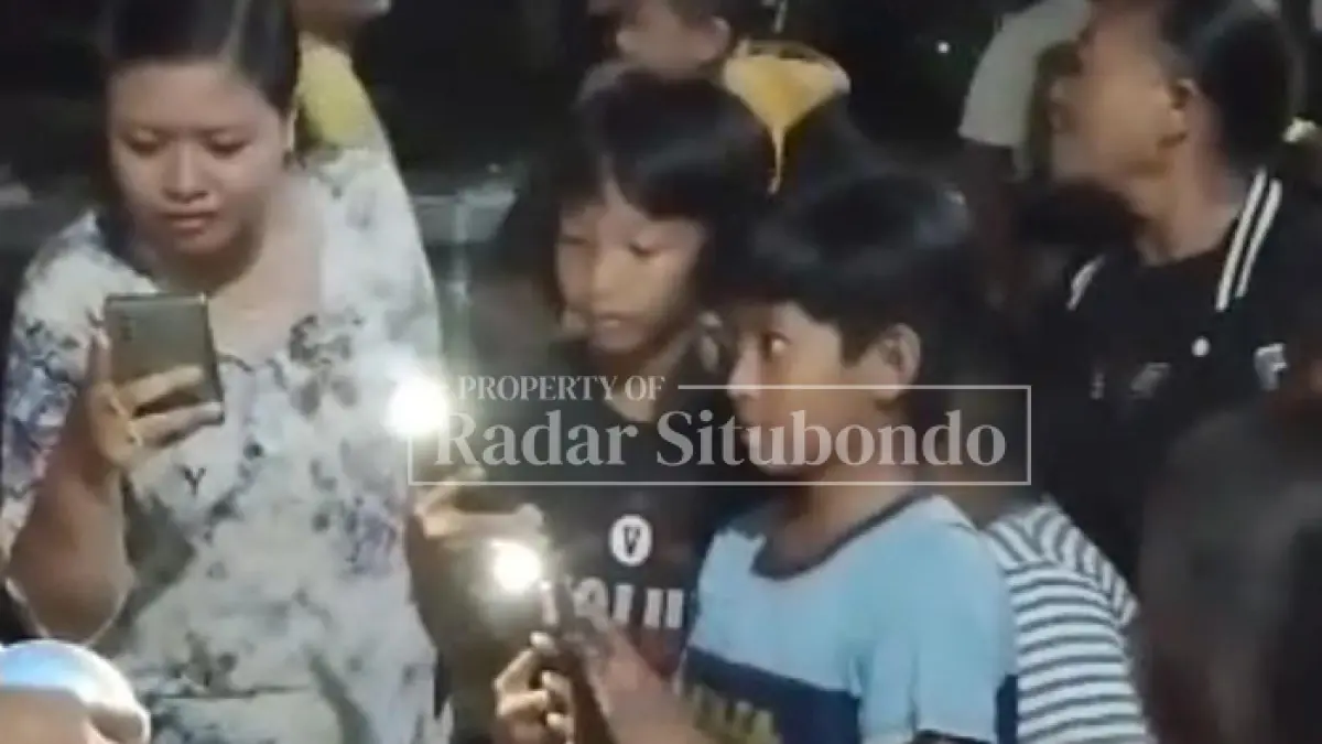EVAKUASI ULAR: Warga mengabadikan gambar ular Kobra hasil tangkapan petugas pemadam kebakaran (Damkar) Situbondo, di rumah Sutiani, warga Perumahan Pesona Bukit Indah, Desa Sumberkolak, Kecamatan Panarukan, Sabtu malam (9/5). (HUMAIDI/JPRS)

