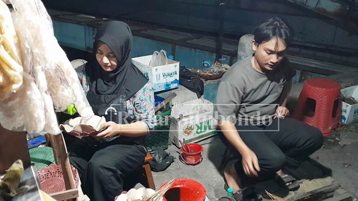 PASUTRI: Egi Puri Hartono, 29 dan Ana Khofifah, 27, sibuk melayani pesanan sate taichan di utara Geledek Macan (UGM) Kelurahan Patokan, Kecamatan/ Kota Situbondo, Kamis (14/5). (HUMAIDI/JPRS)
