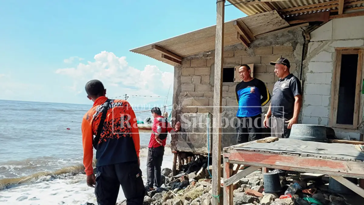 BENCANA ALAM: Anggota BPBD Situbondo meninju rumah rusak di pinggir pantai Dusun Pesisir, Desa Landangan, Kecamatan Kapongan, Jumat (22/5). (HUMAIDI/JPRS)